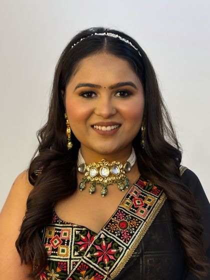 A smiling portrait of the client, showing how the makeup brightens her face and complements her traditional yet modern outfit.