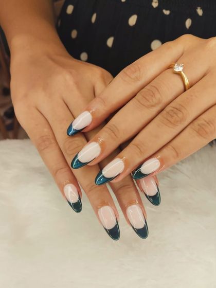 A deep and dramatic French manicure. This look uses a glossy, dark teal for the tips on a long almond-shaped nail, creating a sophisticated and moody vibe.