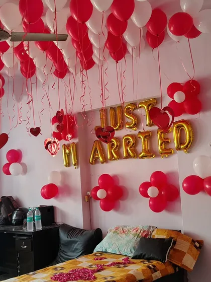 Another angle of the 'Just Married' room decoration, showing the red and white balloon flowers on the wall and the foil letters.