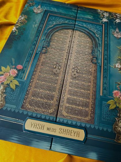 This stunning gate-fold invitation is designed to look like an ornate royal door, rendered in a beautiful shade of teal with intricate gold detailing.