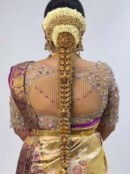 The back of a blouse is a canvas for creativity. This piece showcases a unique cutout design framed by delicate, cascading beadwork, adding a touch of modern glamour to a traditional silk saree. It’s all about those beautiful, unexpected details.