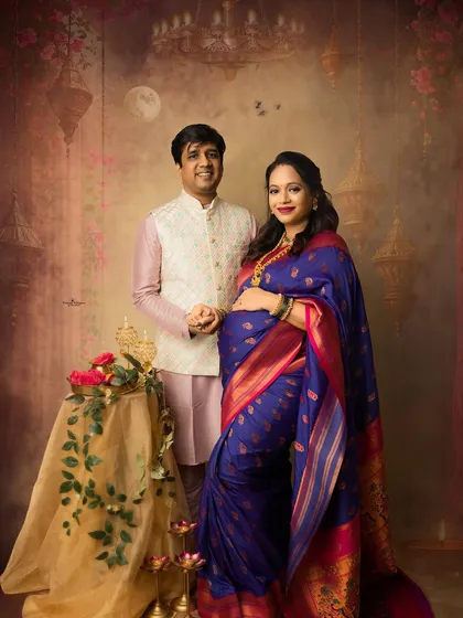 A classic couple's portrait from a festive Diwali session. The husband's traditional jacket complements his wife's beautiful blue saree, creating a perfectly coordinated and elegant look.