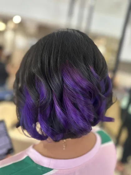 For those who want a playful pop of color, I created this peek-a-boo purple look. It's a fun way to experiment with vivid hair color, adding a flash of personality to a classic bob haircut.