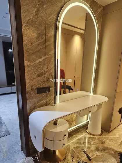 I love creating statement pieces like this custom dresser. It features a minimalist curved design, a built-in arched mirror with ambient LED lighting, and unique cylindrical drawers with brass details for a touch of glamour.
