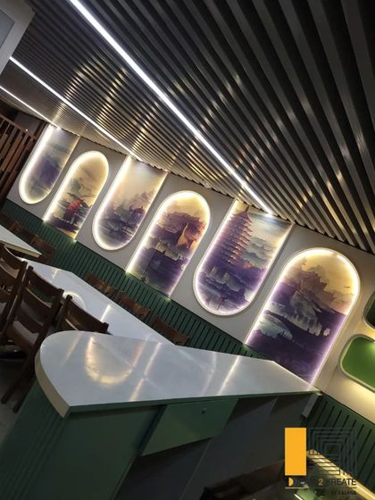 A tilted view of the restaurant's feature wall, showing how the backlighting creates depth and highlights the custom artwork.