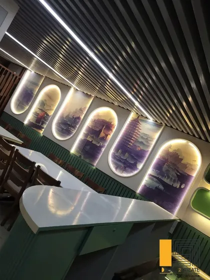 A tilted view of the restaurant's feature wall, showing how the backlighting creates depth and highlights the custom artwork.