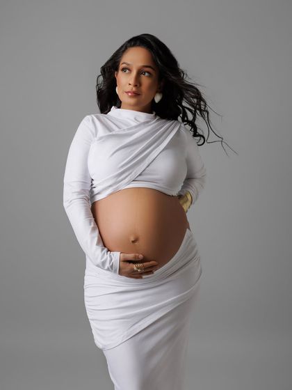 A powerful and modern portrait in a unique white draped gown, with wind in her hair for a dynamic effect.
