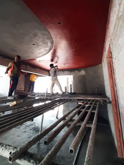 Artisans applying red oxide finish to the curved ceiling at the TAPMI Centre. This large-scale application of a traditional craft required close collaboration and shared expertise.