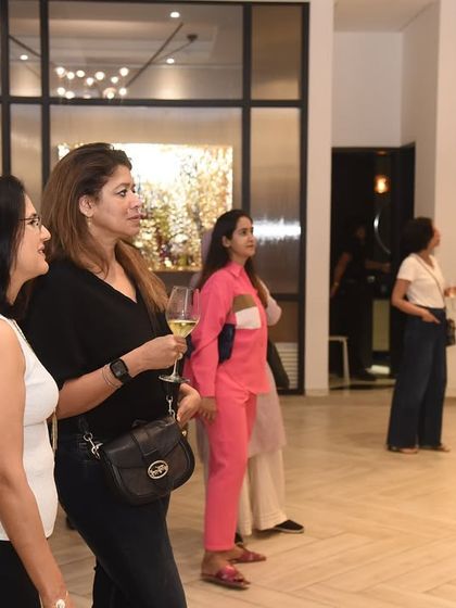 Guests contemplating a large-scale painting during an exhibition. We curate our shows to include pieces that command attention and invite closer inspection, fostering a sense of discovery.