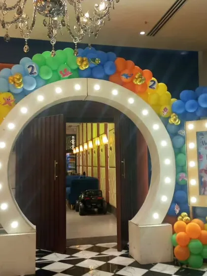 Make a grand entrance for your guests. This large lighted circular archway, framed by a colorful sea-themed balloon garland, set an exciting tone for this party right from the door. We also added a custom welcome board with the birthday boy's picture.