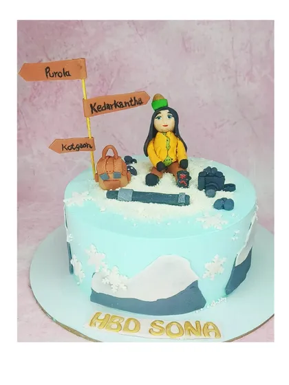A cake for a snow trekker, complete with fondant mountains and trail signs. This is a butterscotch buttercream cake celebrating a love for adventure.