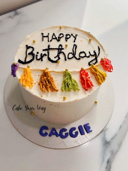 A pretty half-kg cake with a simple tassel garland design.