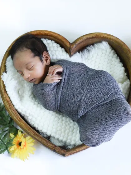 So tiny and perfect. In our newborn sessions, we create a safe and cozy space, using soft props like this heart-shaped bowl to photograph your baby's earliest, most peaceful moments.