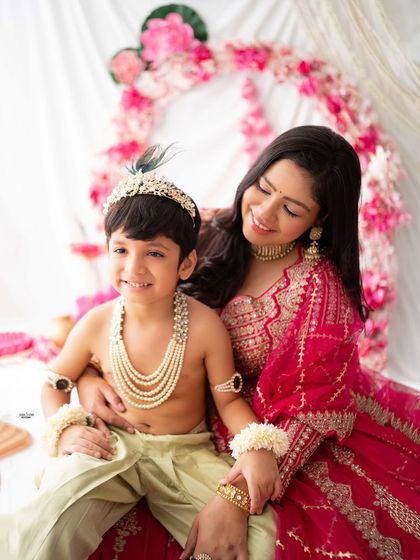 A tender moment between mother and son, both looking stunning in their traditional attire.