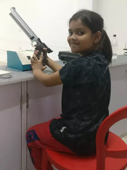 A proud smile from nine year old Koushiki Chauhan at our Gurgaon branch. She is holding a competition grade air pistol, the same type used in the Olympics.