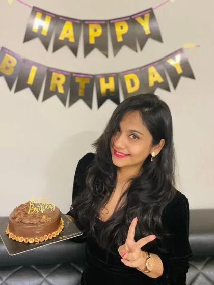 A happy customer celebrating her birthday with our classic chocolate cake. It's an honor to be a part of these personal and joyful moments.