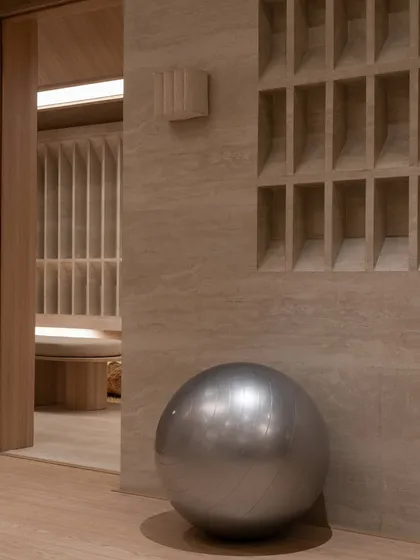 A detail showing the interplay of textures: smooth wood, natural stone, and a gridded storage unit. Even functional elements are treated as part of the architectural composition.