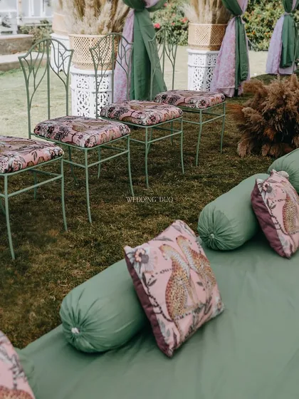 Going floral-free with a nod to nature. This seating arrangement combines green floor cushions with leopard-print throw pillows and wrought-iron stools, creating a unique jungle-inspired theme.