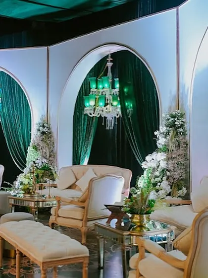 I designed intimate lounge areas with classic white sofas and emerald green chandeliers. These spaces, framed by elegant white arches and velvet drapes, offered guests a luxurious retreat within the larger celebration.