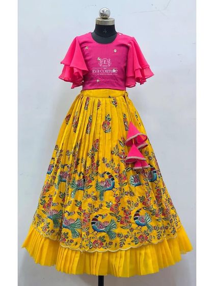 A modern lehenga with a yellow peacock-print skirt and a pink crop top with flutter sleeves.