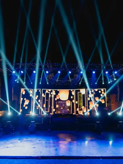 The grand stage setup with dramatic blue spotlights and an LED screen showing floating lanterns, ready for a night of unforgettable performances.