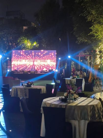 The evening view of the Diwali party setup, showing the stage, lighting, and guest tables ready for the celebration.