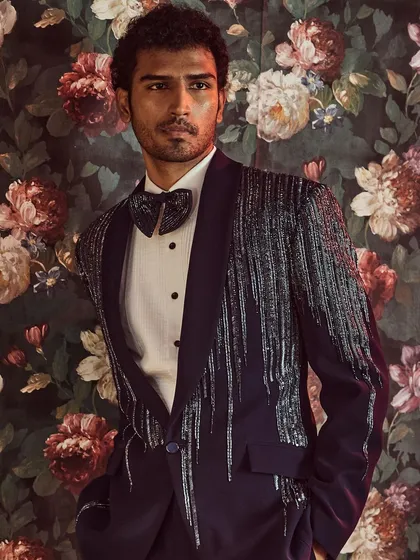 We redefine formal wear with this modern tuxedo, featuring a shawl lapel embellished with a cascade of kut-dana work for a touch of sophisticated glamour.