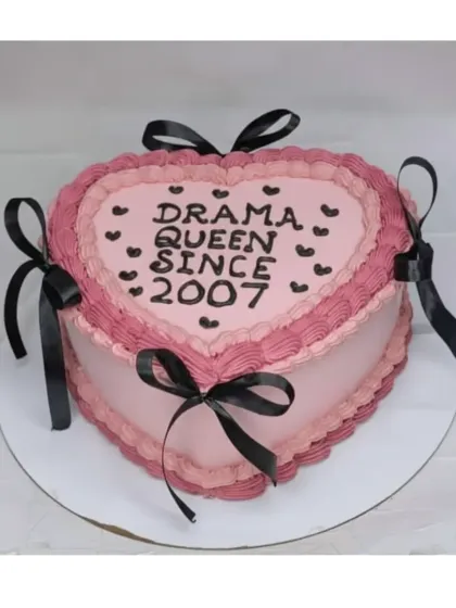 A fun "Drama Queen" cake with vintage piping. This heart-shaped choco-blueberry cake combines pink frosting with black ribbons for a bold and stylish look.