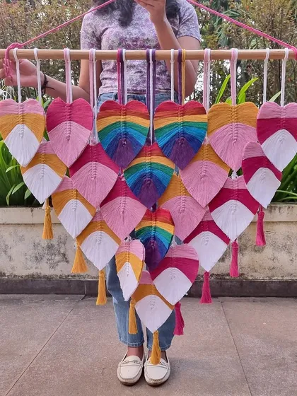 Bringing a burst of boho vibes with these multicolored macrame leaves. This piece, featuring rainbow hearts, is a cheerful and artistic addition to any living room.