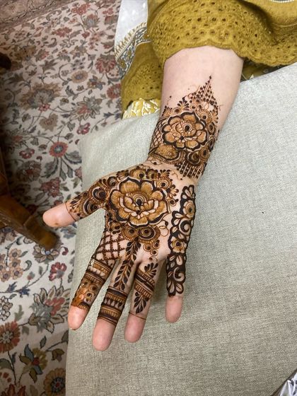 A simple yet bold Arabic floral design on the palm, with delicate details on the fingers.