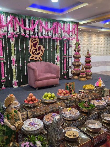 A wider view of the Seemantham stage, showing the hanging floral garlands and traditional props.