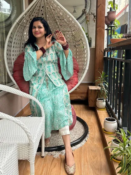 Another angle of my balcony, showing how I've styled this little nook. The combination of the wicker swing, plants, and ethnic decor creates a peaceful and stylish outdoor living area.