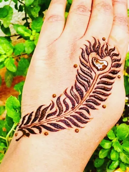 A simple yet striking peacock feather design on the back of the hand, perfect for a quick and artistic henna application.