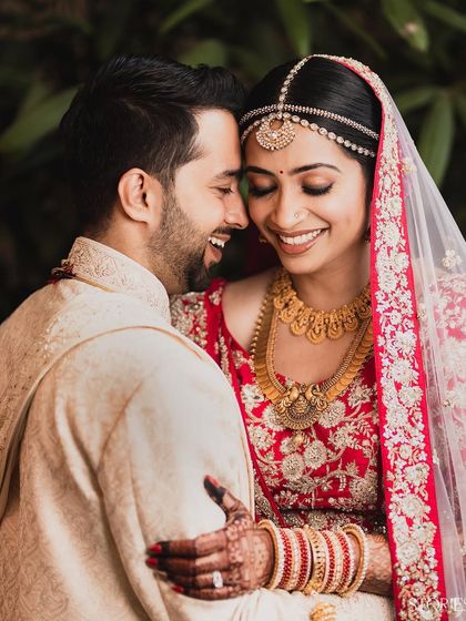 A beautiful, happy portrait of a newly married couple. Their genuine smiles and comfortable embrace showcase the pure joy and love they share in this candid moment.