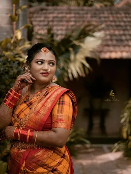 A wider shot from the same outdoor session, this image shows how we use the environment to frame our subjects. The traditional house and lush greenery provide a perfect, authentic backdrop for this classic portrait pose.