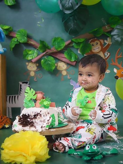 Digging into a jungle cake! This is what a successful cake smash looks like, full of fun, frosting, and unforgettable memories.