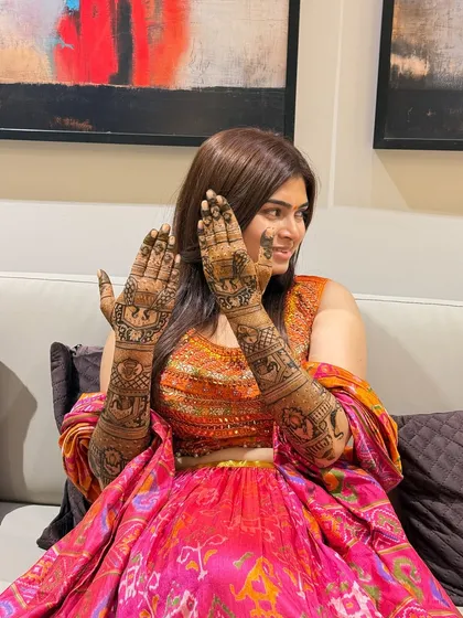 A full view of the bride's mehendi, featuring elephant processions and other royal motifs. The design covers her hands and arms completely, as is traditional for many brides.