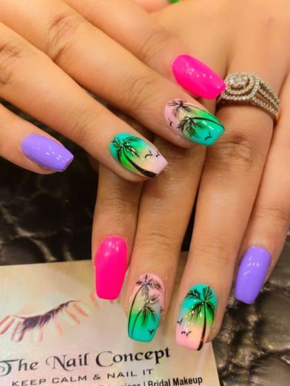 A vibrant, tropical-themed set of nails. The design features a mix of bright pink, purple, and turquoise nails with hand-painted palm trees over a sunset ombre.