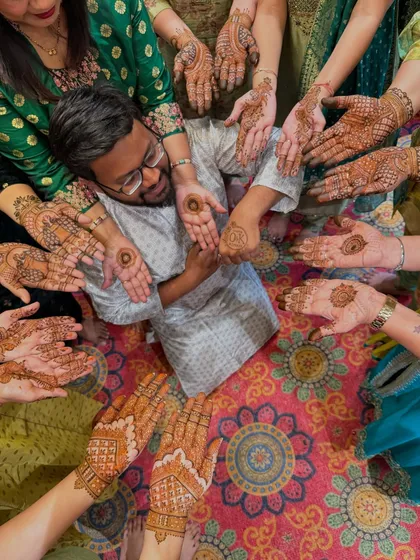 The groom surrounded by the lovely ladies of his family, all showing off their beautiful mehendi. It's always a fun session with the groom's side.