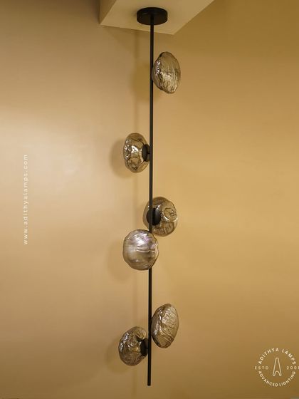 This vertical fixture features textured, moon-like chrome orbs attached to a central black rod. It's a striking, artistic piece that works well in corners or narrow spaces, adding a touch of celestial-inspired modernism.