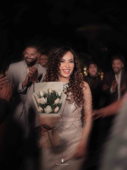 A candid, motion-blur shot of the bride smiling as she enters her reception, bouquet in hand.