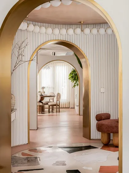 The entrance lobby of the "Marshmallow" penthouse, where a custom chandelier encircles the volume like a halo, emitting a soft glow.