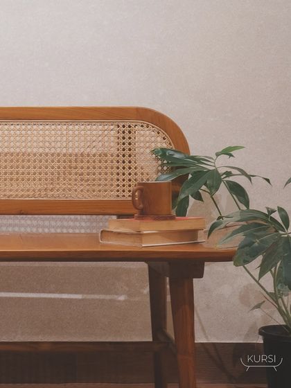 The 'Roma' bench styled with books and a plant, showing its versatility as a functional piece of art in any room.