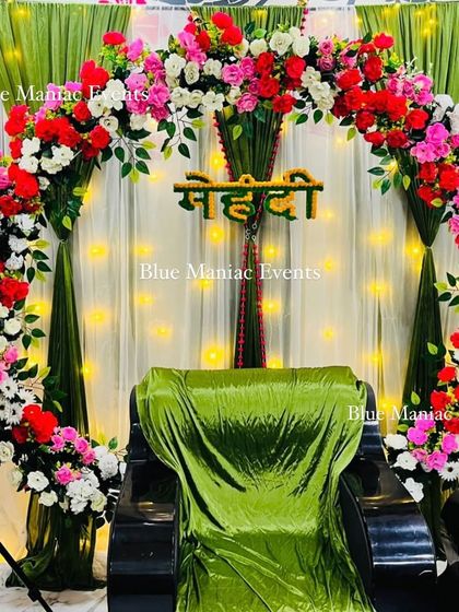 A closer look at the colorful circular floral arch for a Mehendi ceremony, showing the mix of flowers and the 'Mehendi' sign.