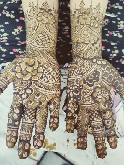 The palms are filled with a rich tapestry of traditional Indian mehndi patterns, perfect for a bride.