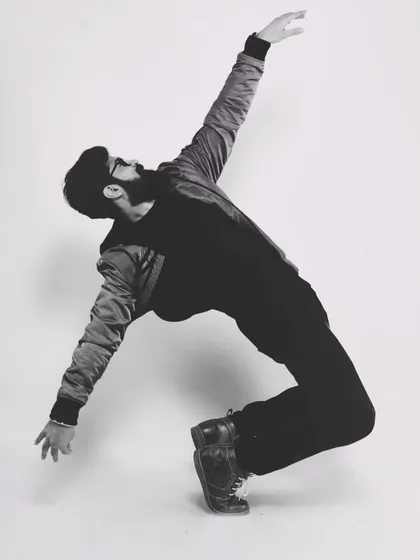 An artistic pose that captures the grace and extension in dance. This black and white shot highlights the lines and form of the movement.