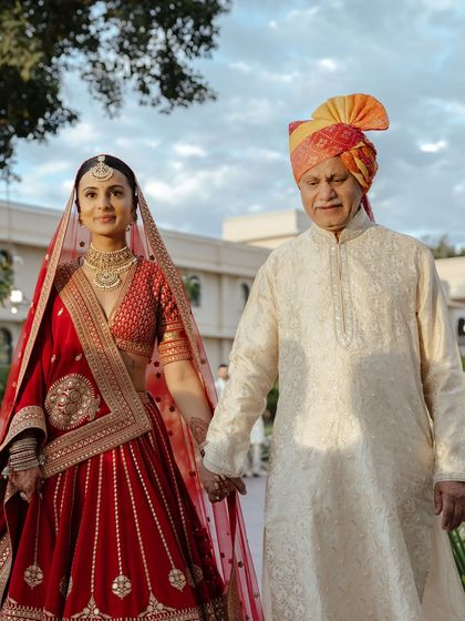 A touching moment as the bride walks with her father. Her makeup is soft and elegant, perfect for these emotional memories.