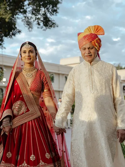 A touching moment as the bride walks with her father. Her makeup is soft and elegant, perfect for these emotional memories.