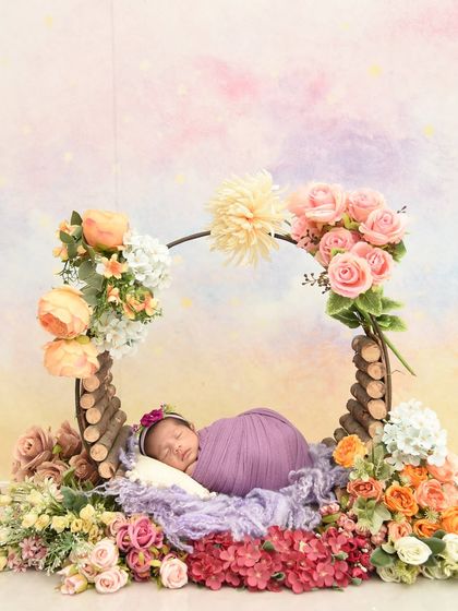 A full view of the rustic prop decorated with purple and peach flowers, showing the entire beautiful arrangement for this newborn shoot.