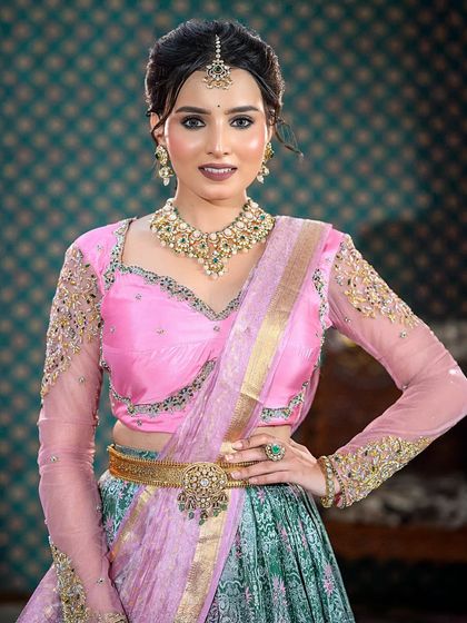 A beautiful half-saree look with a pink and sea-green combination. This demonstrates modern draping styles and color coordination for pre-wedding events.